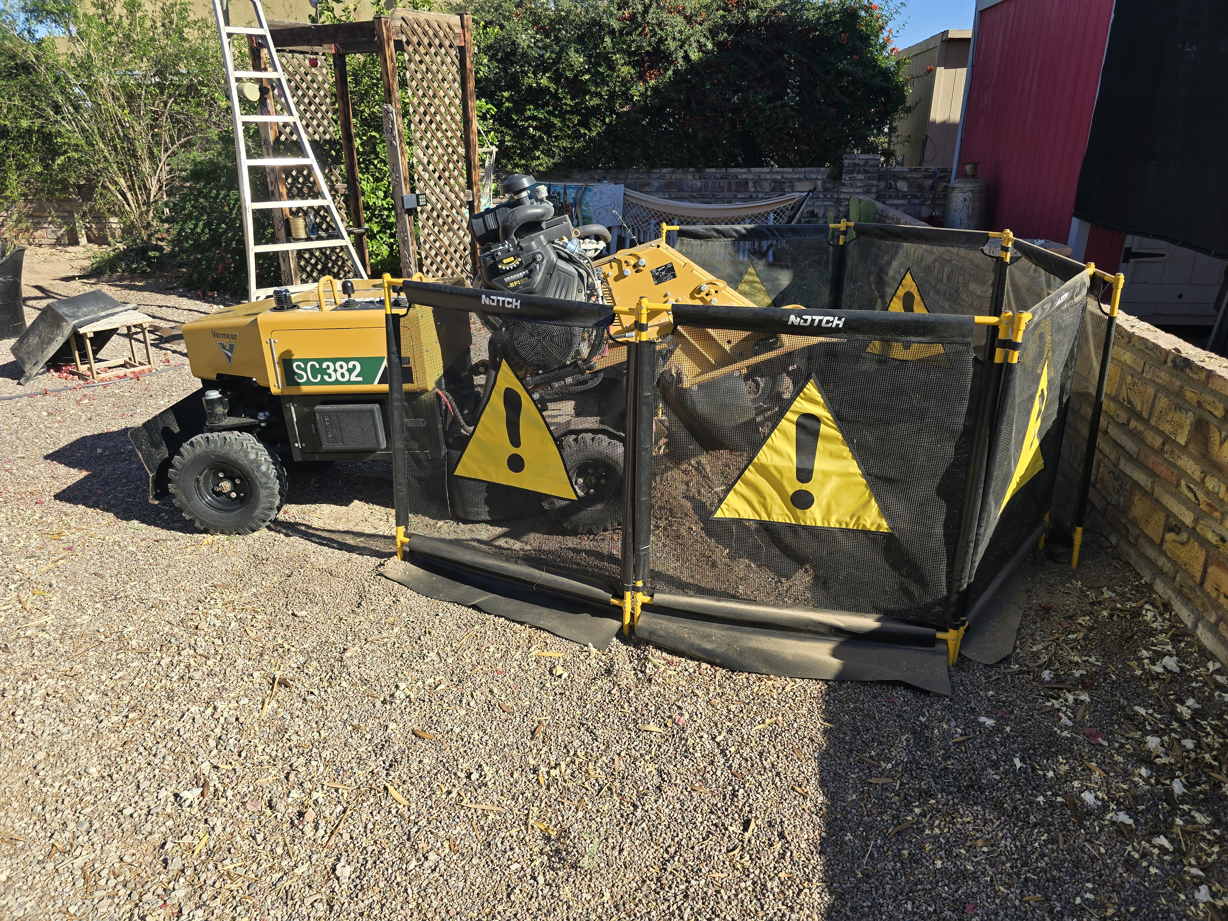 Stump grinding near a wall on a residential property